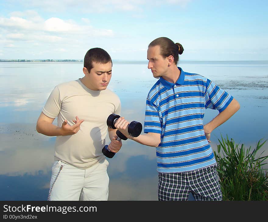 Youth funs. Two fellows with dumb-bells. Healthy lifestyle. Youth funs. Two fellows with dumb-bells. Healthy lifestyle.