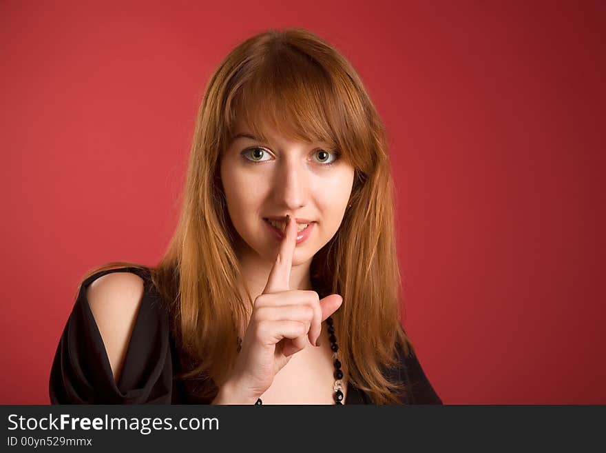 Beautiful girl asking to keep silence isolated on red background. Beautiful girl asking to keep silence isolated on red background