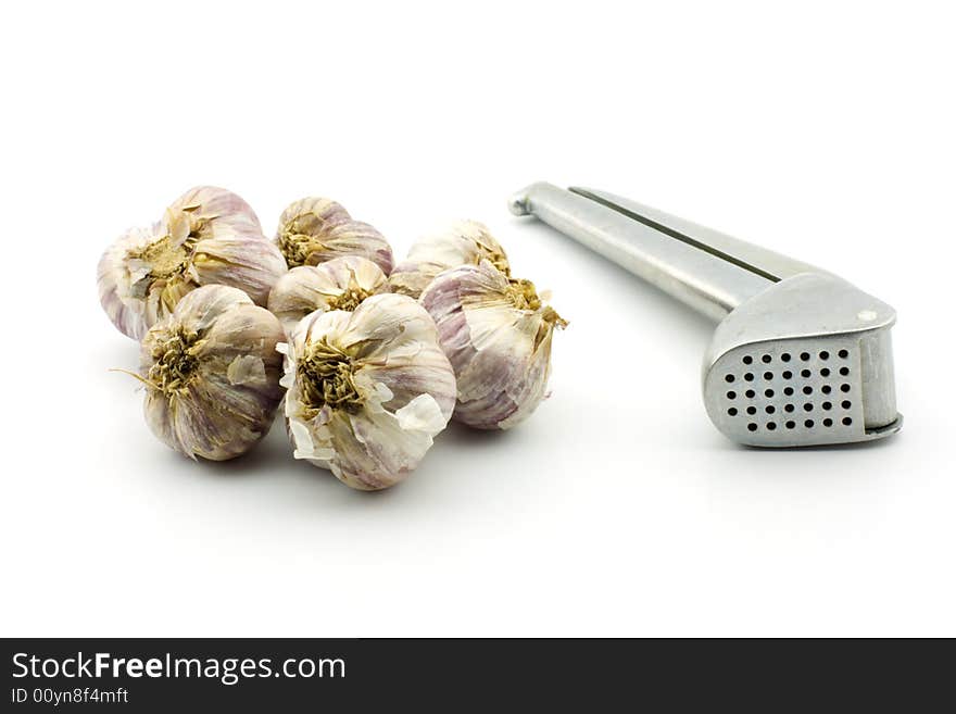 Raw garlic and garlic press, isolated