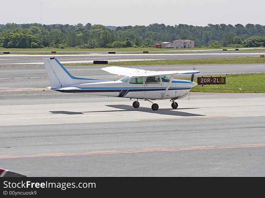 A small private airplane taxiing on the runway before takeoff. A small private airplane taxiing on the runway before takeoff