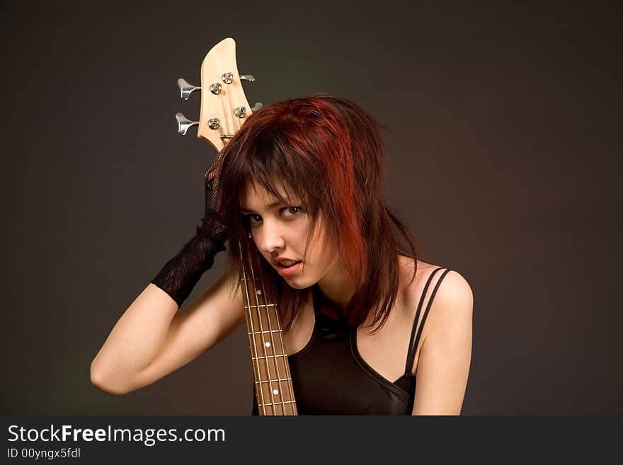 Sensual girl with bass guitar isolated in studio