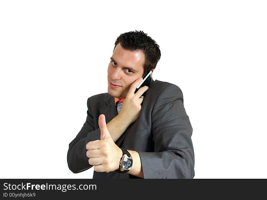 A young business man, talking over a cellphone, holding his thumb up. A young business man, talking over a cellphone, holding his thumb up