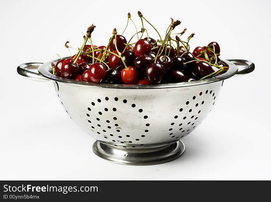 Fresh cherry in Colander on white background