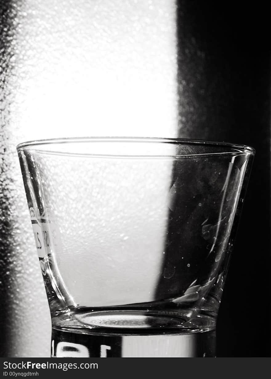 An empty Glass illuminated in the backgroud