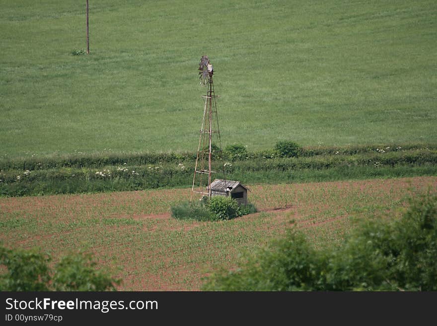 An abandoned windmill sits idle in a field. An abandoned windmill sits idle in a field