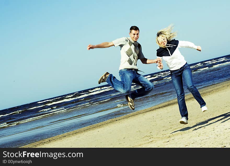 Young couple jumping on the beach. Young couple jumping on the beach.