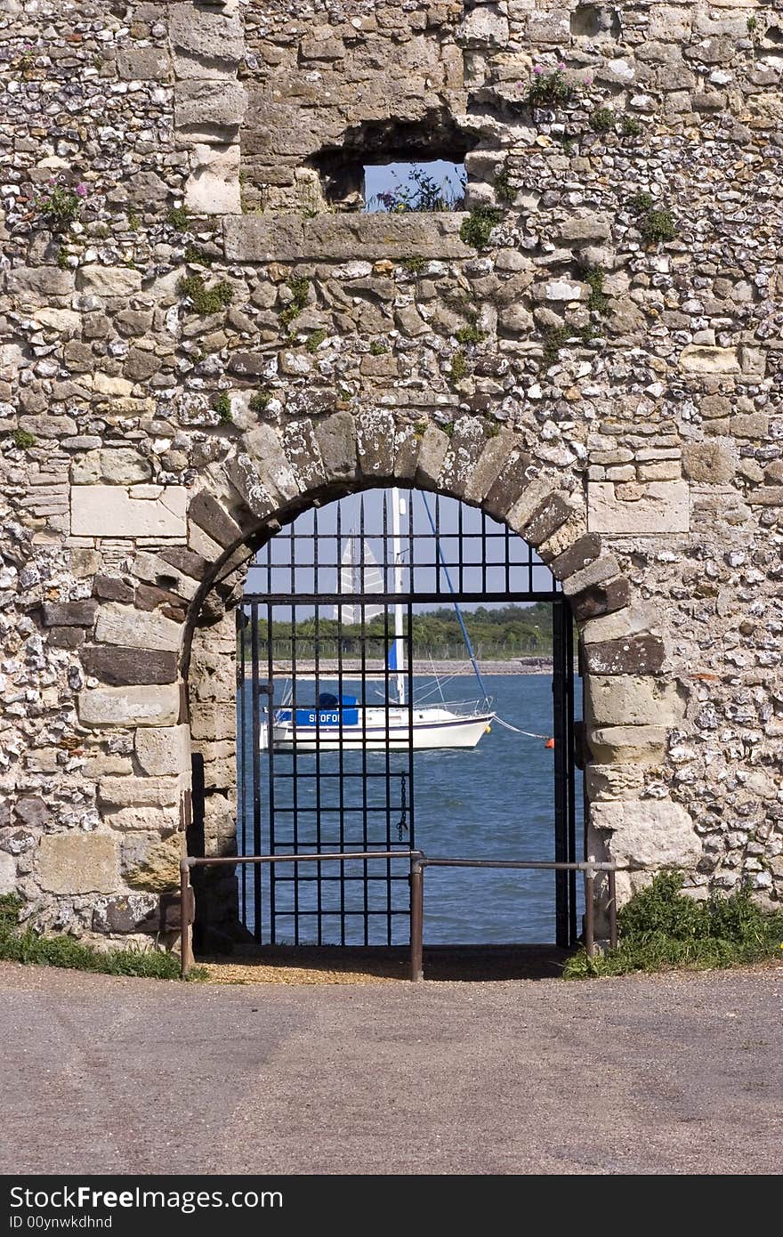 A boat framed by a castle gate. A boat framed by a castle gate