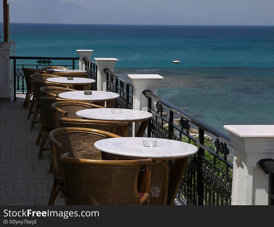 Hotel balcony overlooking a blue sea.