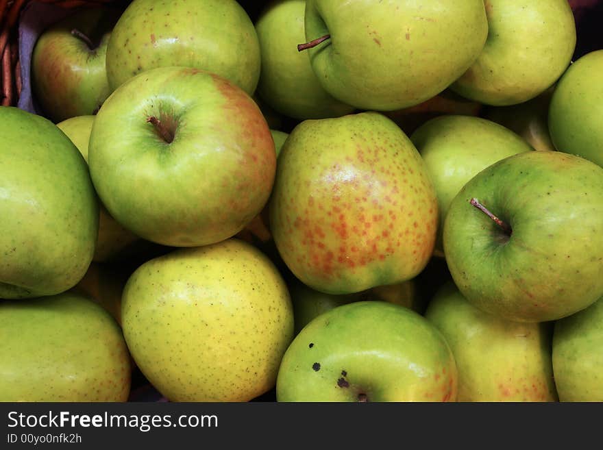 A pile of green apples at a farmers market