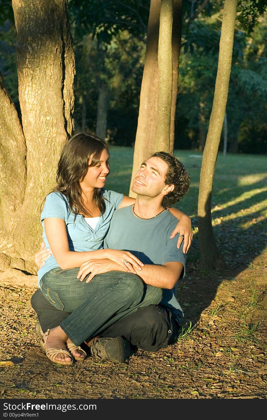 Happy Couple Sitting in the Woods. Vertical