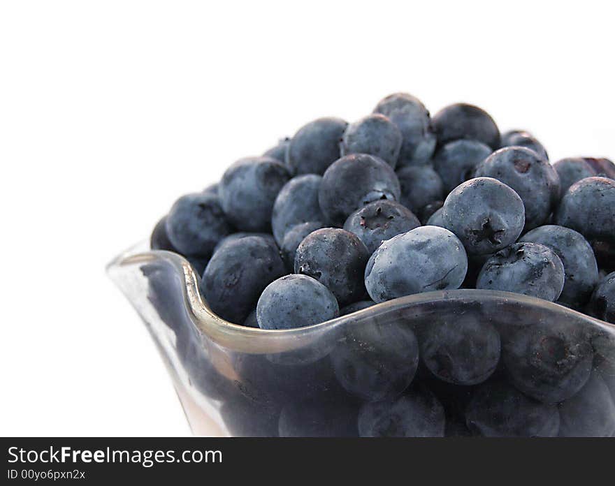 Glass bowl of blueberries taken on white background.