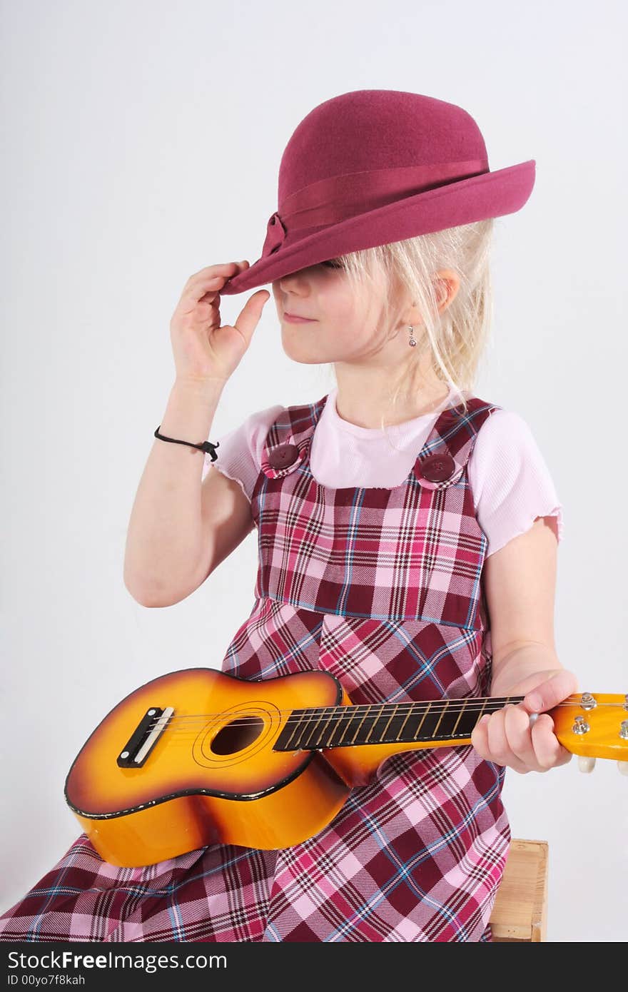 Small girl playing a toy guitar. Small girl playing a toy guitar