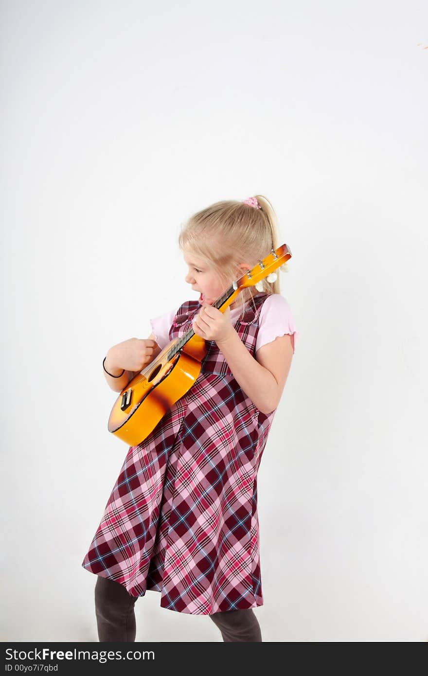 Small girl playing a toy guitar