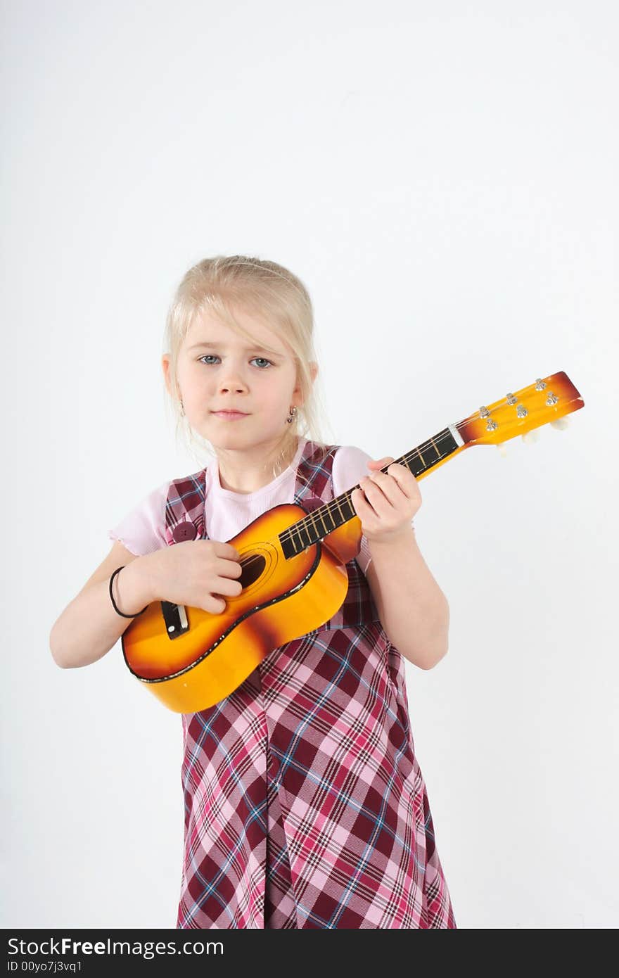 Small girl playing a toy guitar. Small girl playing a toy guitar