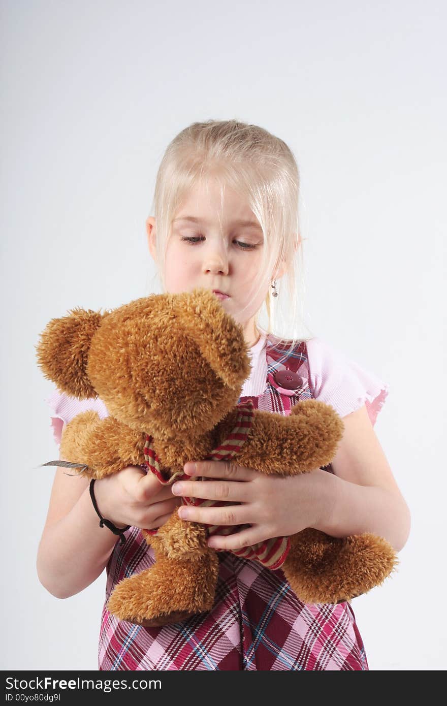 A little girl playing with her teddy bear. A little girl playing with her teddy bear