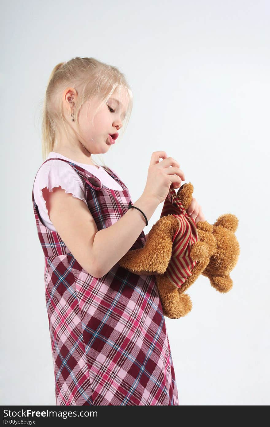 A little girl playing with her teddy bear. A little girl playing with her teddy bear