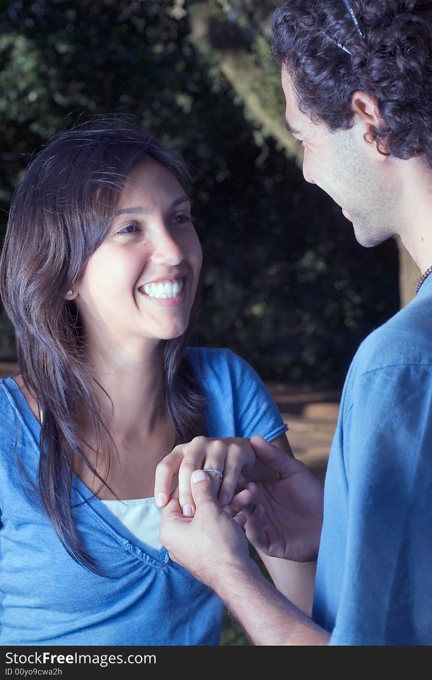 Smiling couple holding hands. It appears as if they just became engaged. Vertically framed photograph. Smiling couple holding hands. It appears as if they just became engaged. Vertically framed photograph