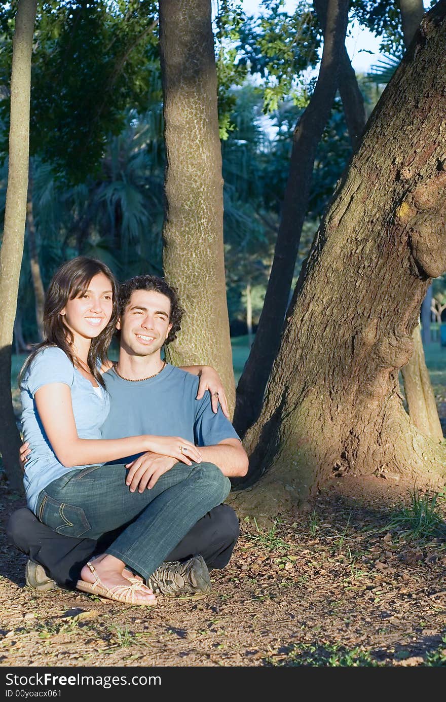 Happy Couple Sitting in the Woods. Vertical