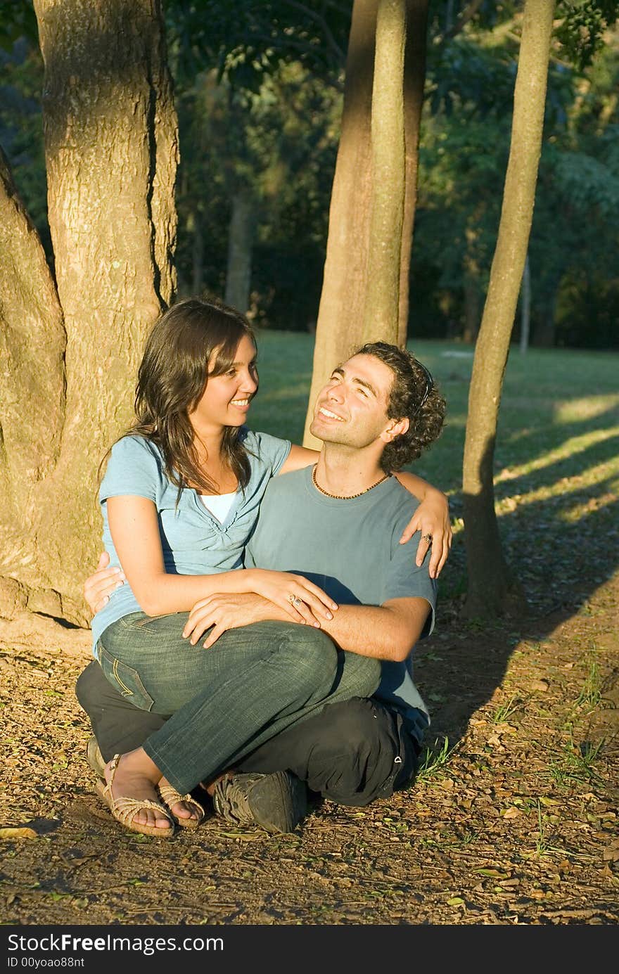 Happy Couple Sitting in the Woods. Vertical