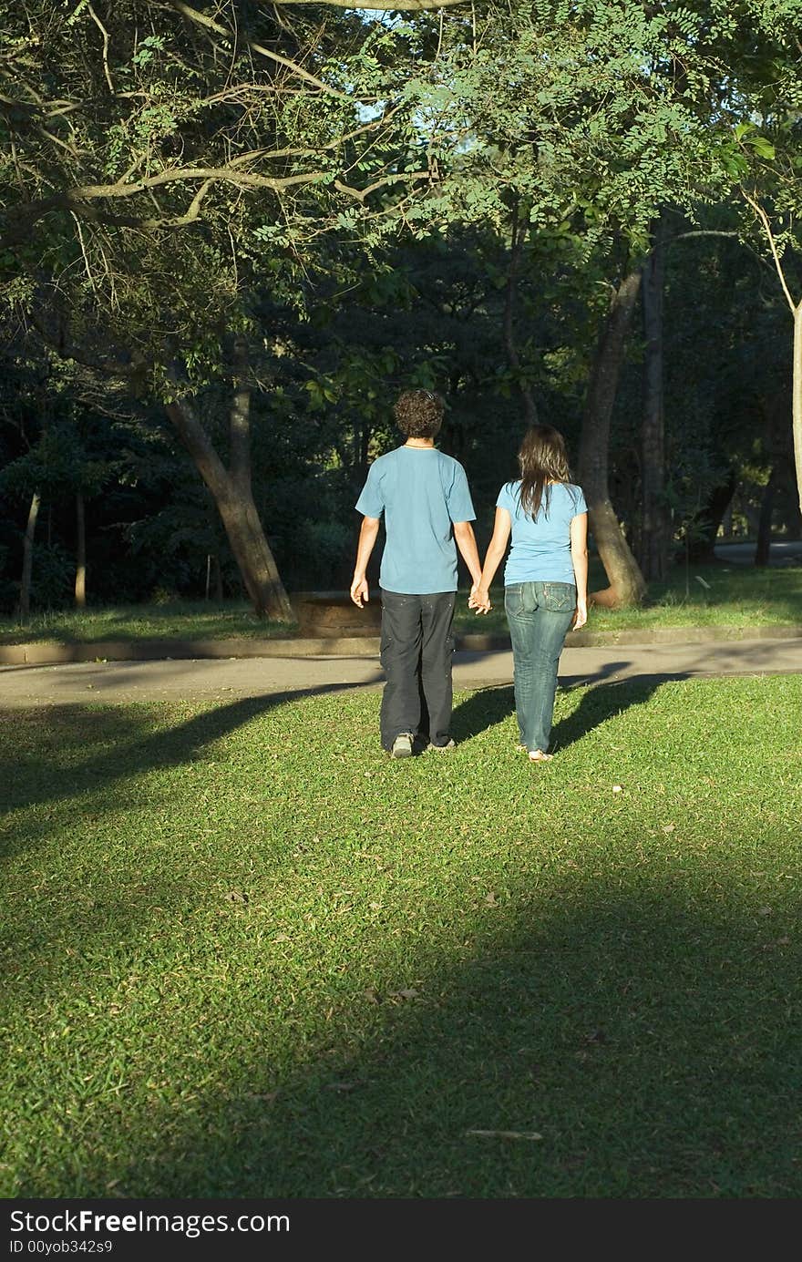 Young Couple Walking Through a Park - Vertical