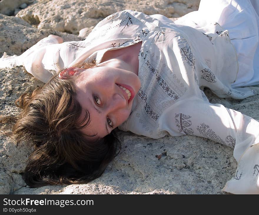 Portrait of Smiling Lady Ethic Dress Lying on Stone