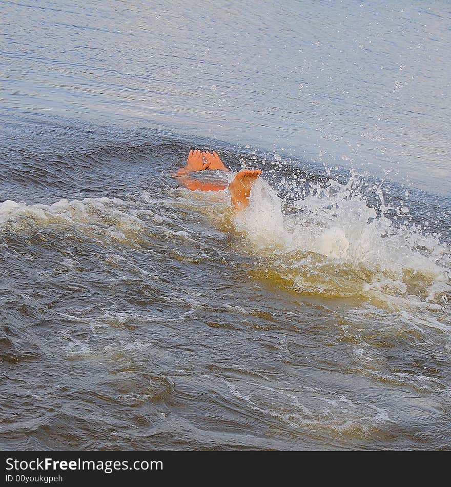 Feet and hands of the young diver are seen above the water