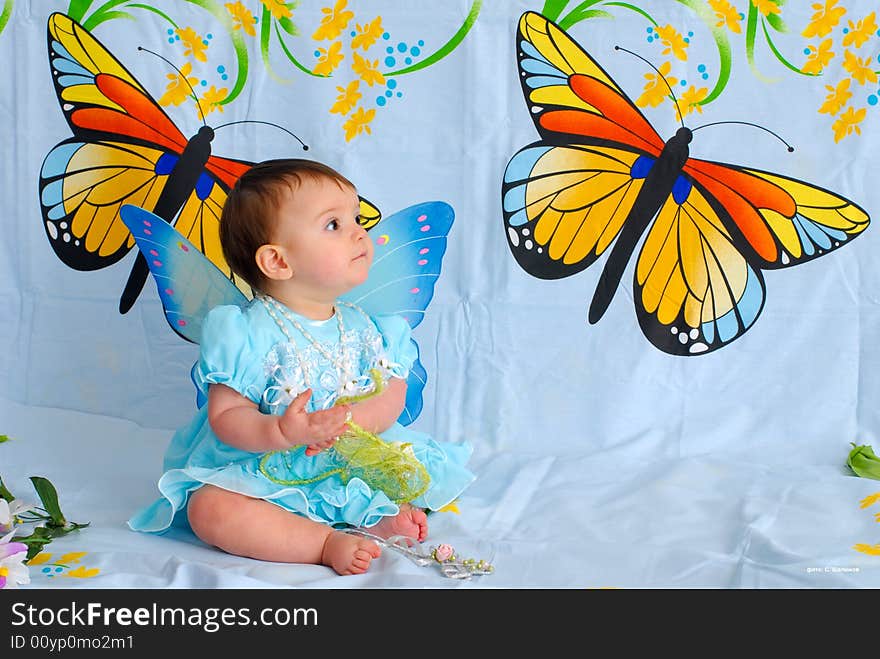 A picture of a sweet little girl in a fancy blue dress with butterfly wings. A picture of a sweet little girl in a fancy blue dress with butterfly wings