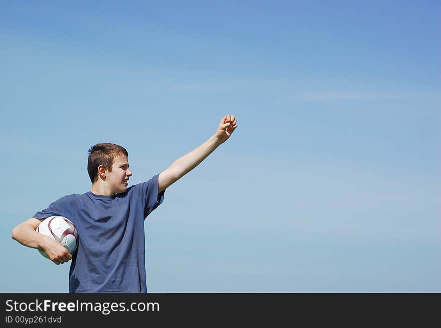 Happy boy playing football on sky background