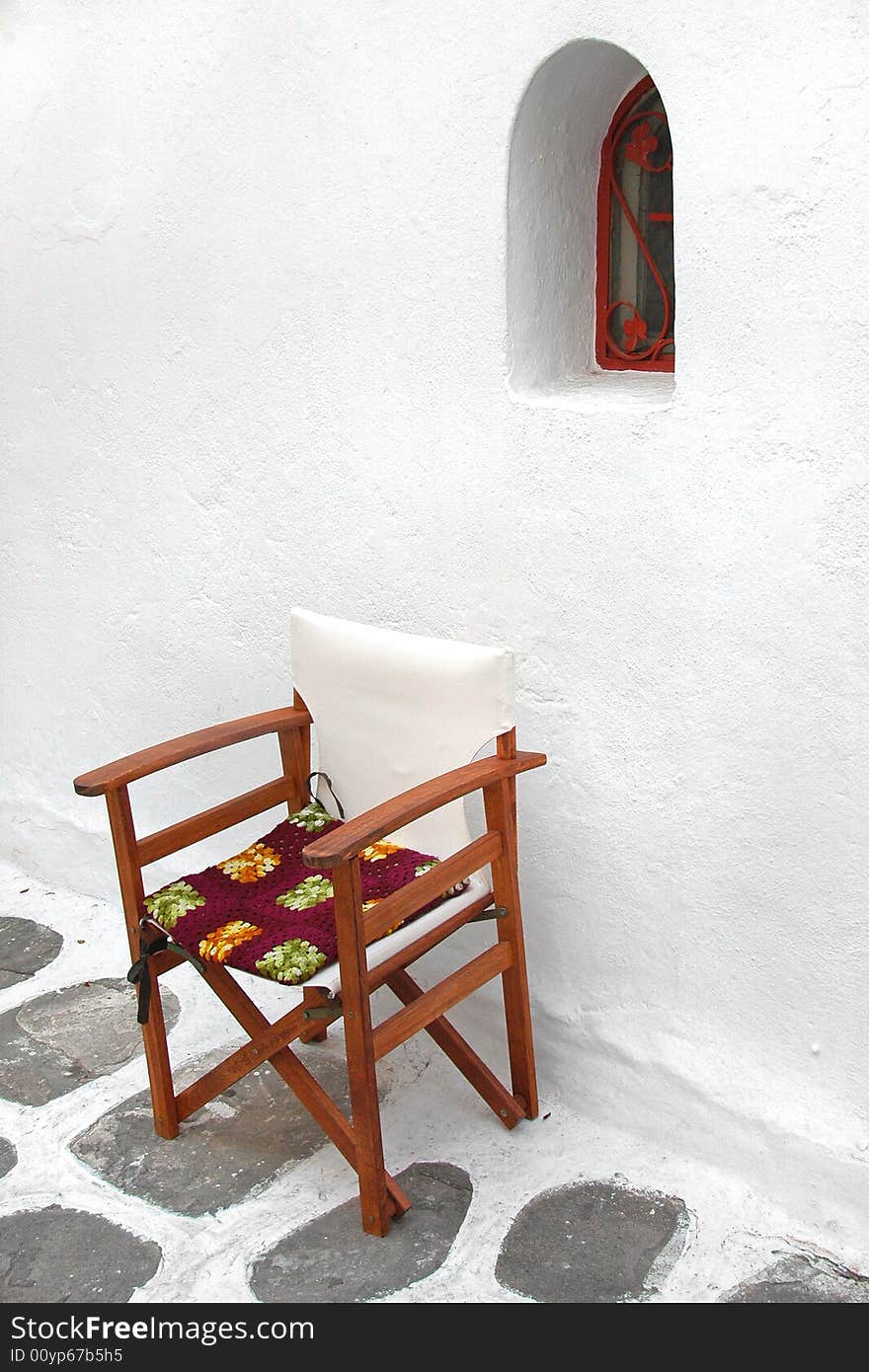 Lone chair beside old Mediterranean building in Greece. Lone chair beside old Mediterranean building in Greece