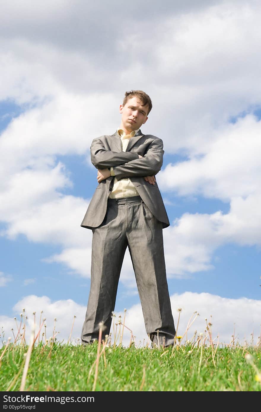 The young businessman standing on a green grass