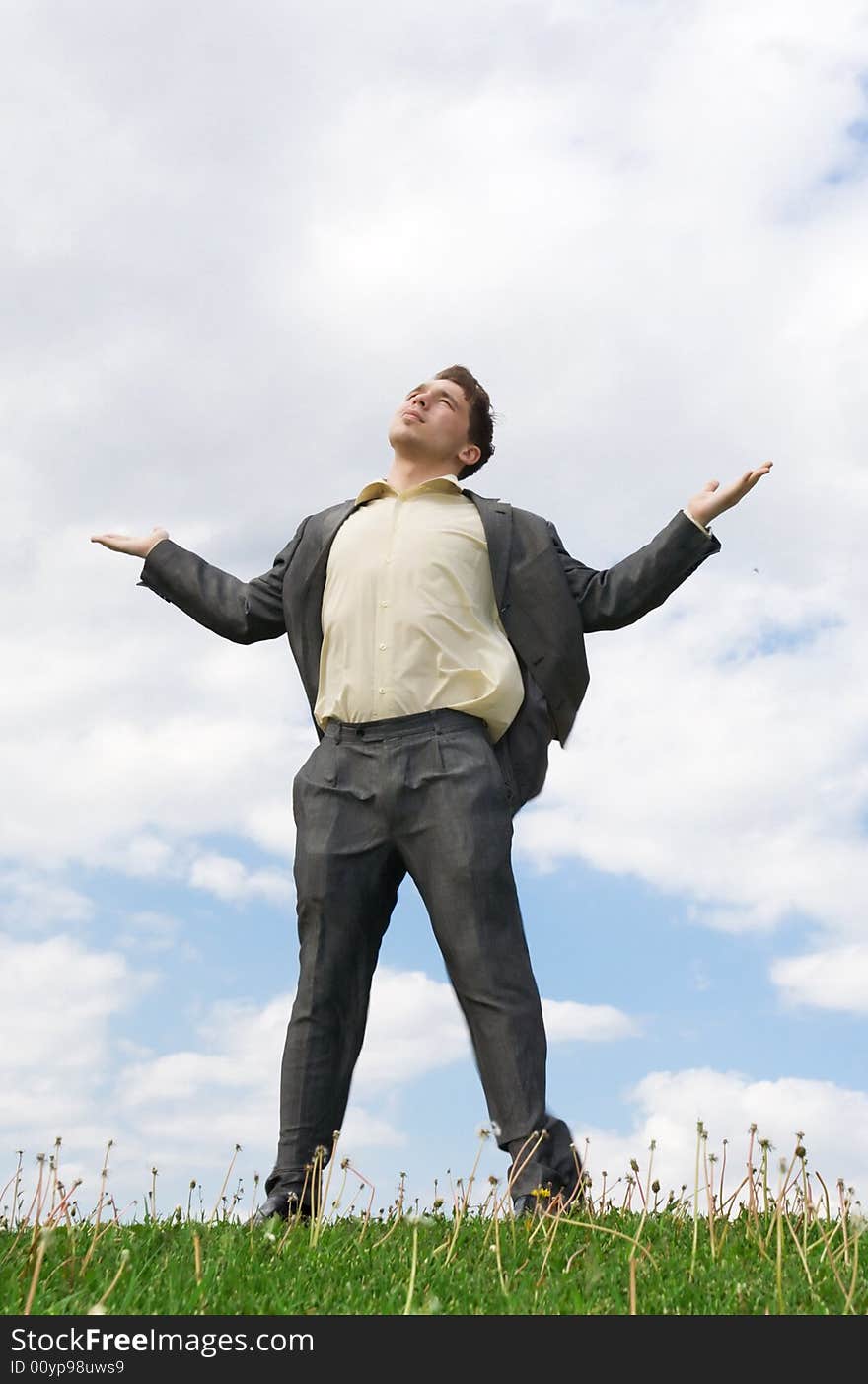 The young businessman standing on a green grass