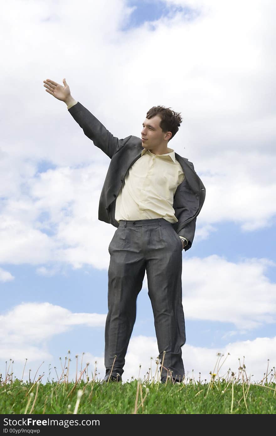 The young businessman standing on a green grass