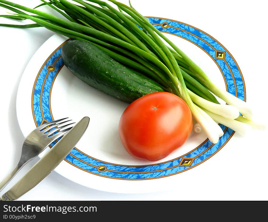 Green onion, cucumber and tomato on the plate. Green onion, cucumber and tomato on the plate