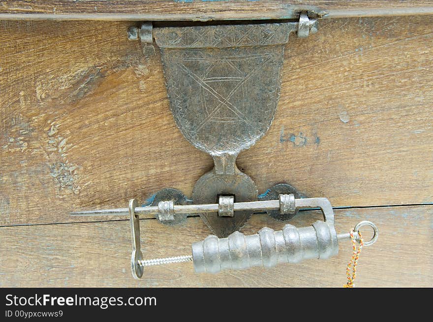 Antique locking mechanism or padlock on a restored antique chest with a hinged bracket lock.