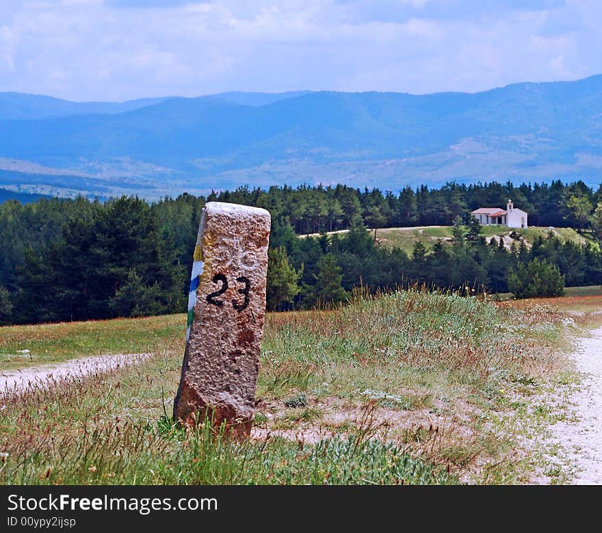 Column near the road and church far away.
Photo taken in Bulgaria in May 2008