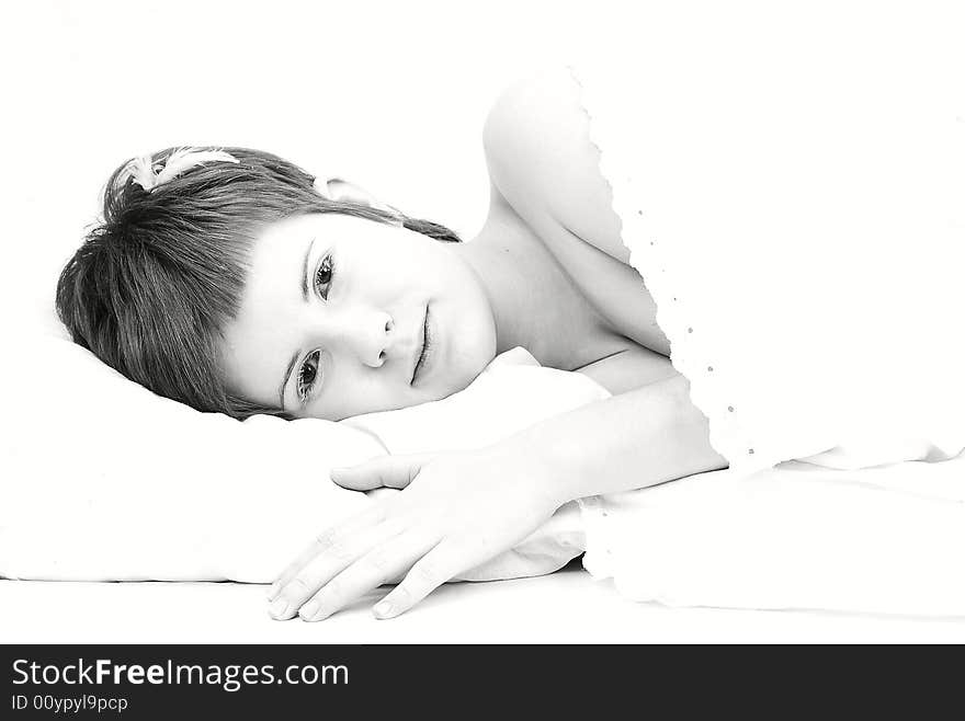 Portrait of short haired girl with white eyelashes and a tiny feather on her head, laying down on a pillow (high key lightning). Portrait of short haired girl with white eyelashes and a tiny feather on her head, laying down on a pillow (high key lightning)