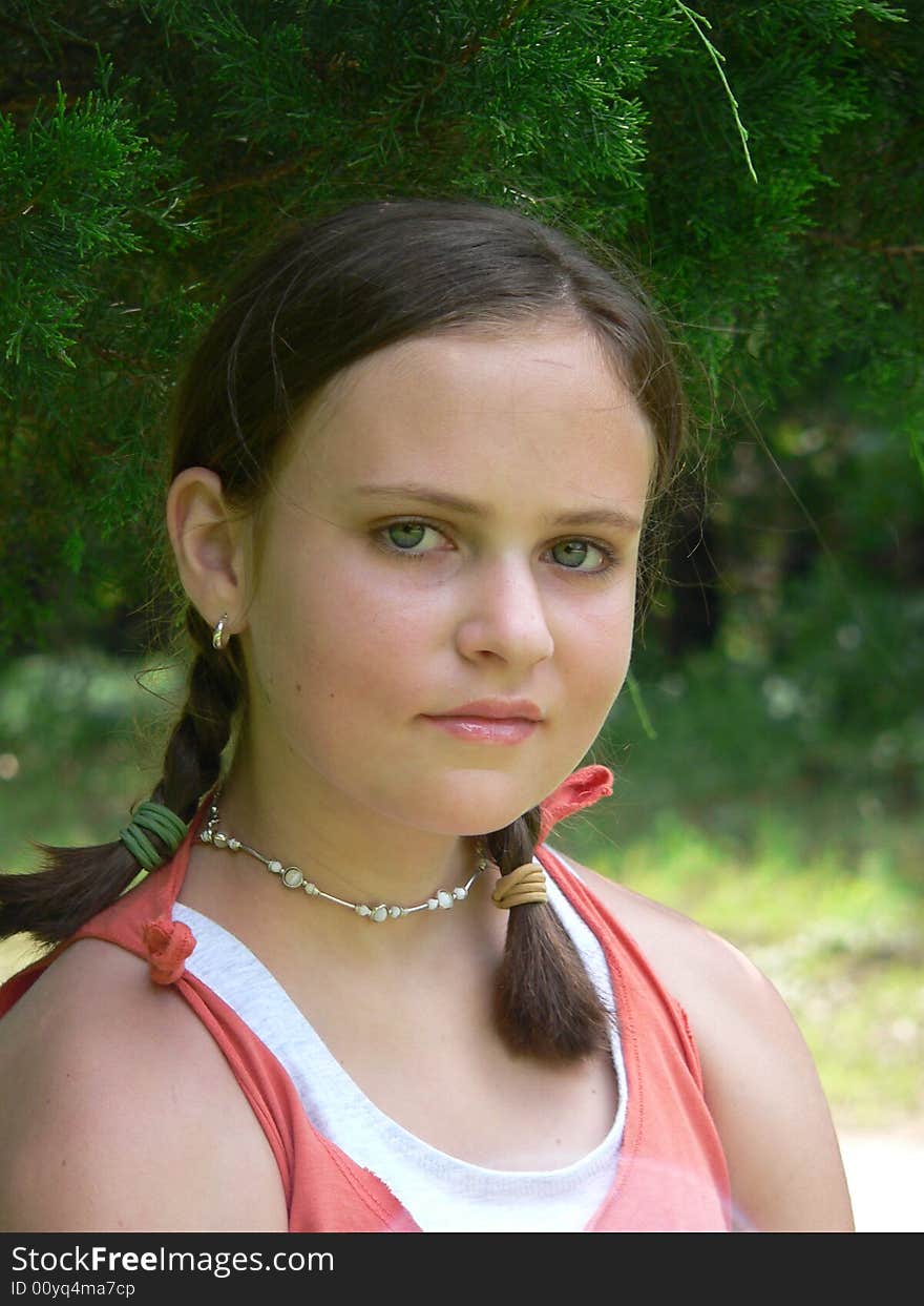 Teenage girl with braids in orange tank with green background. Teenage girl with braids in orange tank with green background