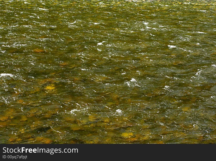 Natural texture. Pure river transparent water with a visible stony bottom - can be used as abstract background. Variant four. Natural texture. Pure river transparent water with a visible stony bottom - can be used as abstract background. Variant four.