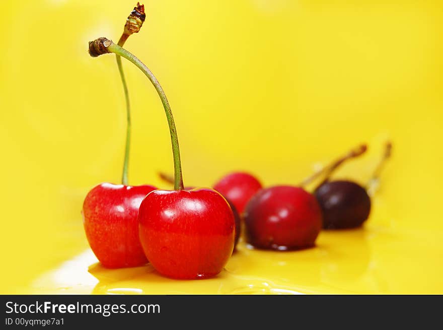 Red cherries on yellow background