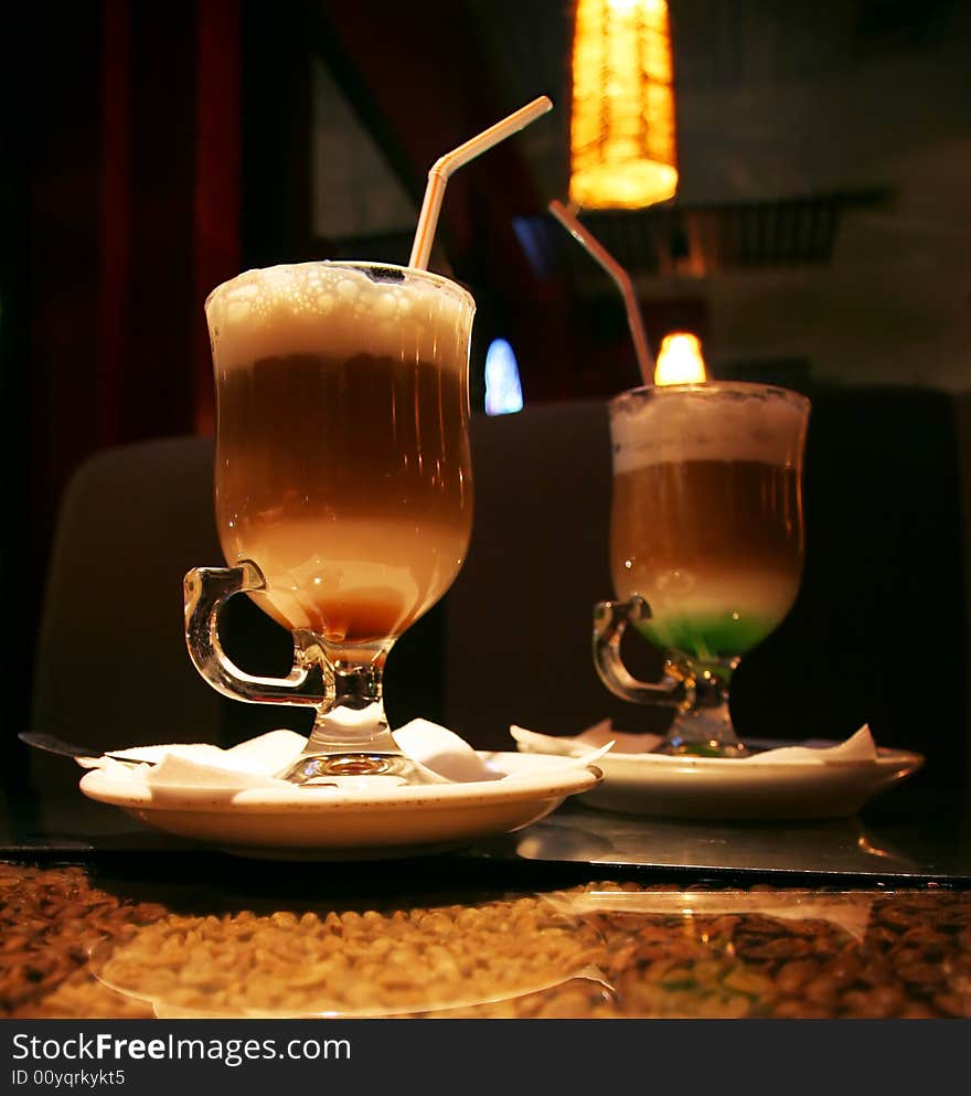 Two cups of coffee in a clear glasses (dark cafe background)