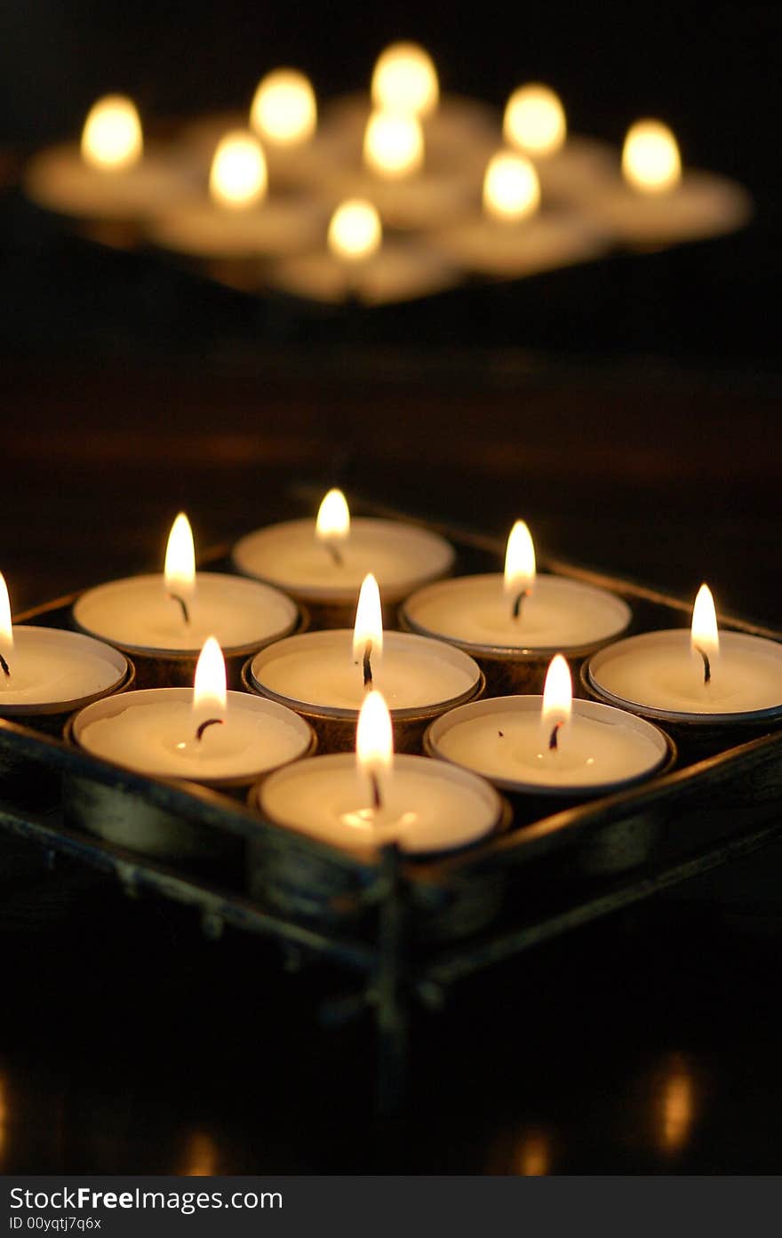 Photo of white candles with flames.