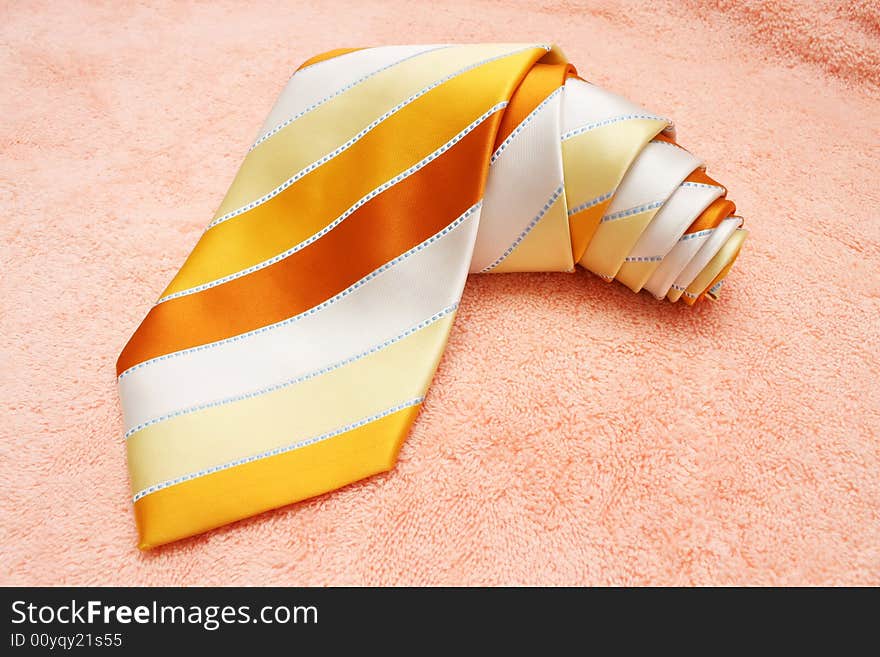 A rolled up necktie on cotton cloth.