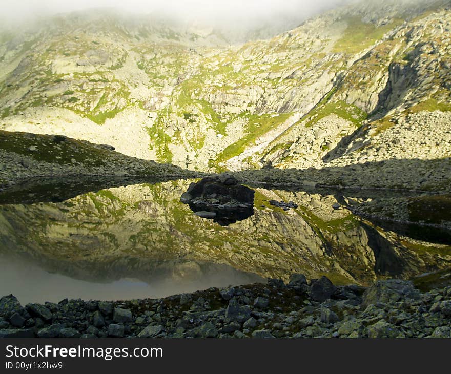 Small mountain pond in mornig time. Beauty mirror effect.