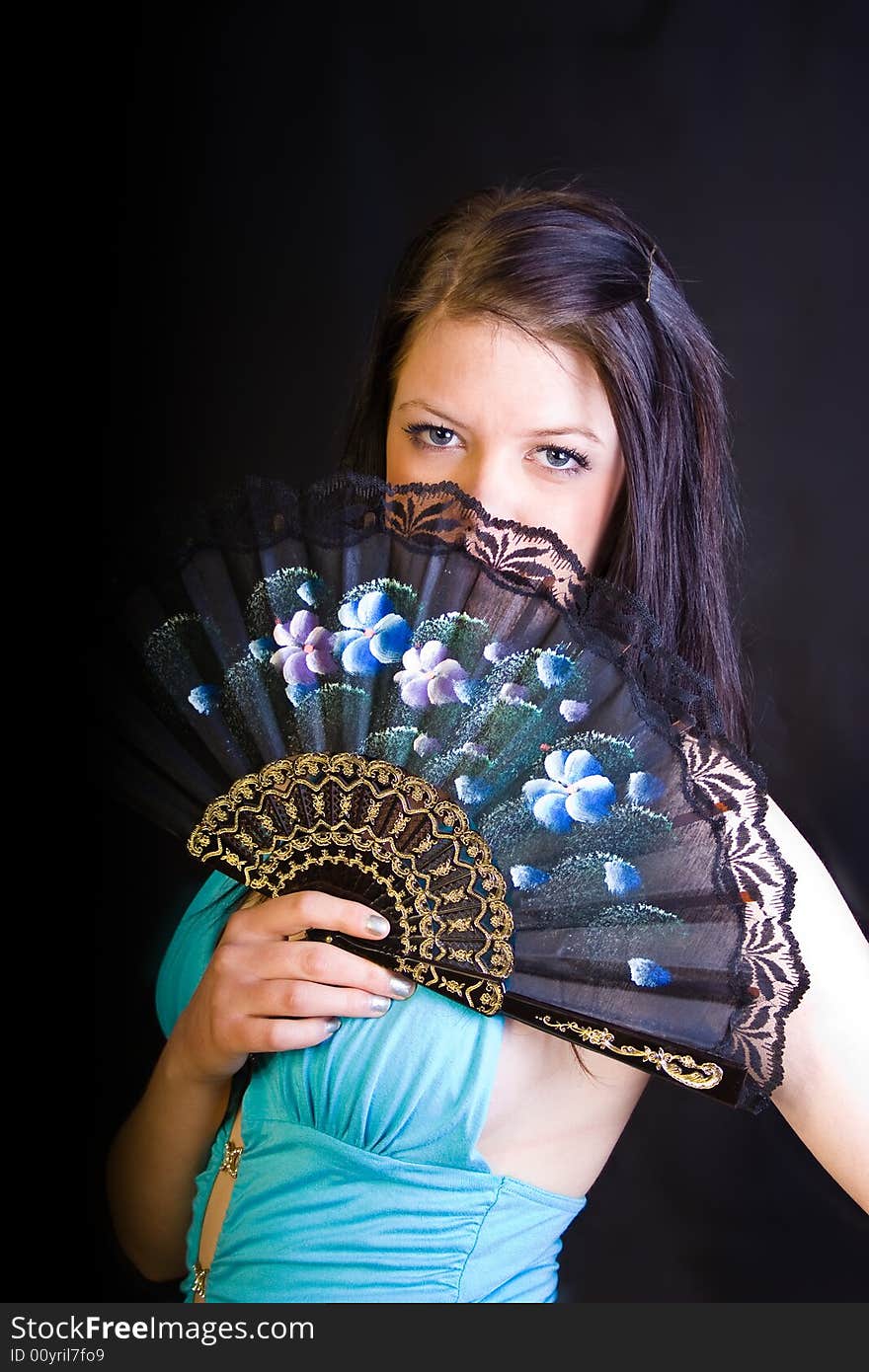 A portrait of an european teenager girl holding a fan