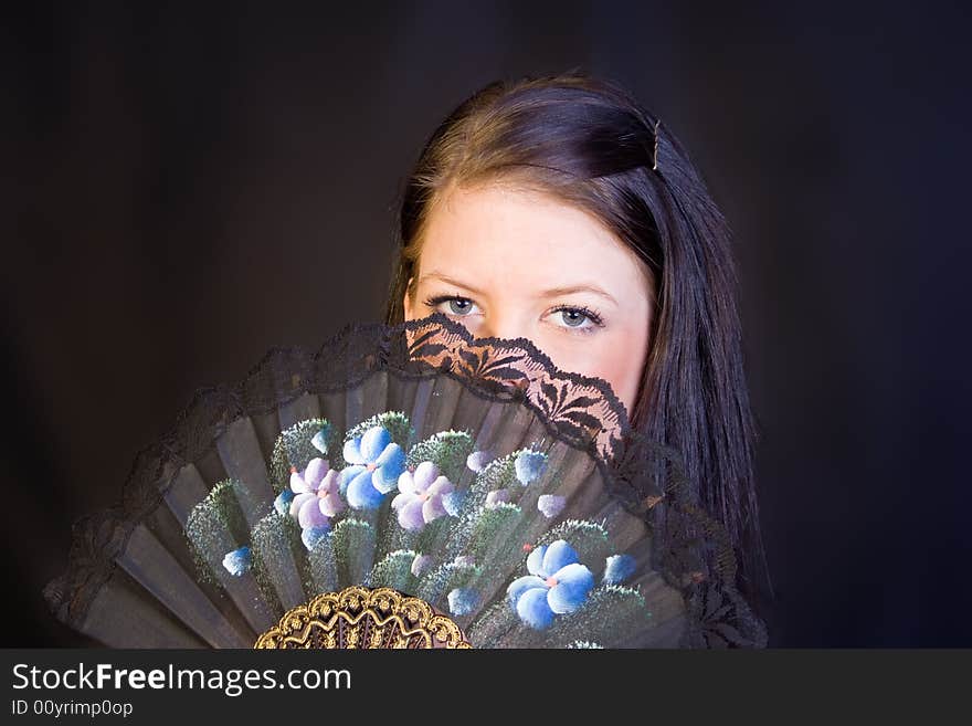 A portrait of an european teenager girl holding a fan. A portrait of an european teenager girl holding a fan