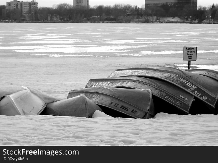 Upturned canoes during a Minnesota winter. The canoes a stacked on top of a frozen lake. Upturned canoes during a Minnesota winter. The canoes a stacked on top of a frozen lake.