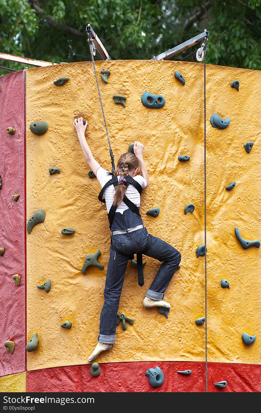 Young girl climbs on training wall. Young girl climbs on training wall