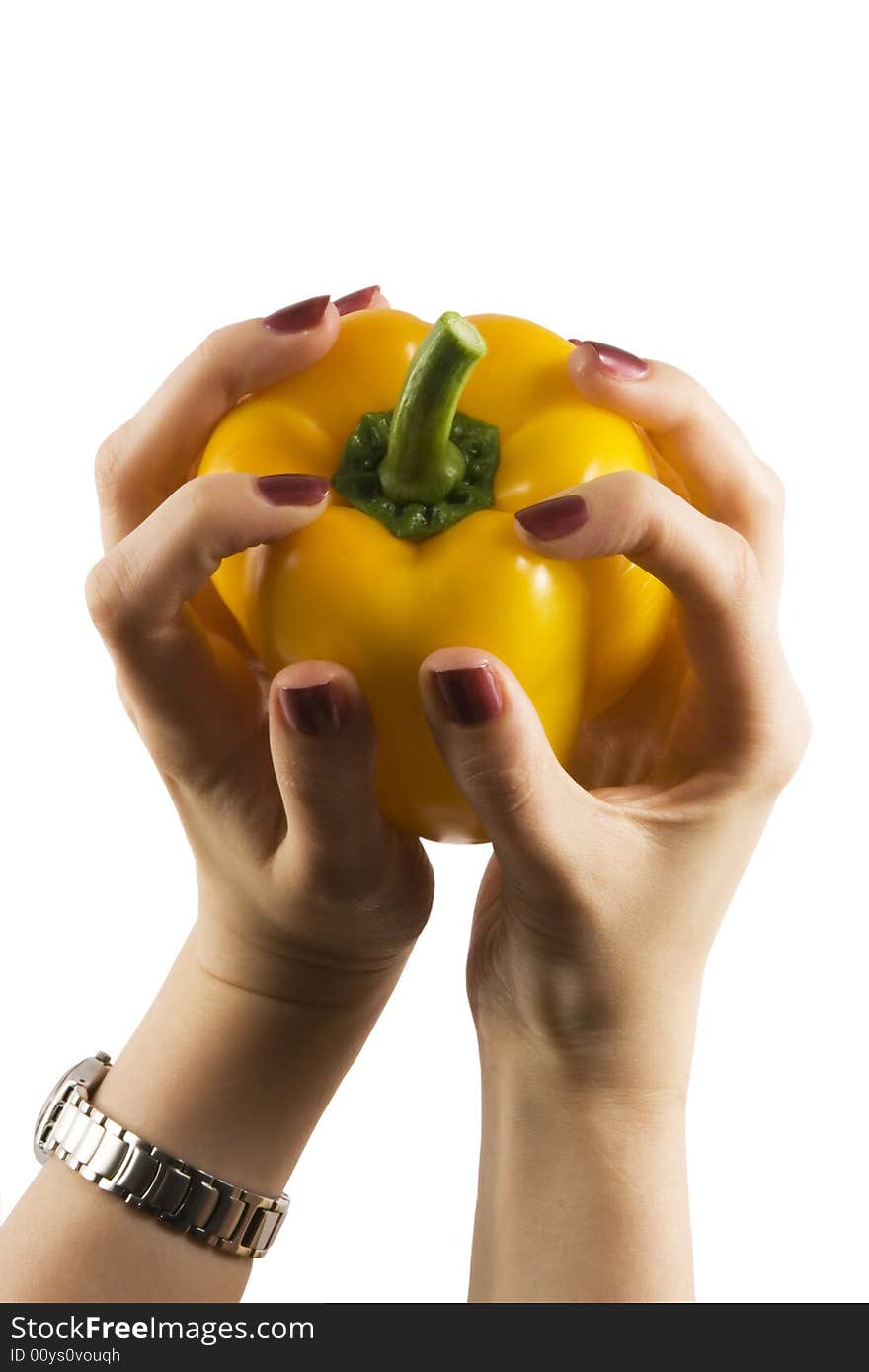 Yellow pepper in a womanish hand with violet nails