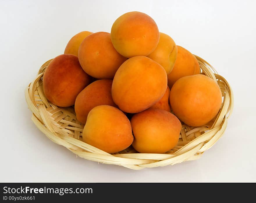 Ripe apricots in the wattled small basket from the arboreal shavings