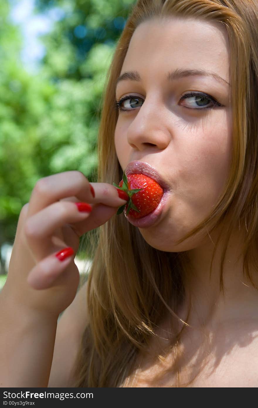 Portrait of the beautiful young girl with strawber